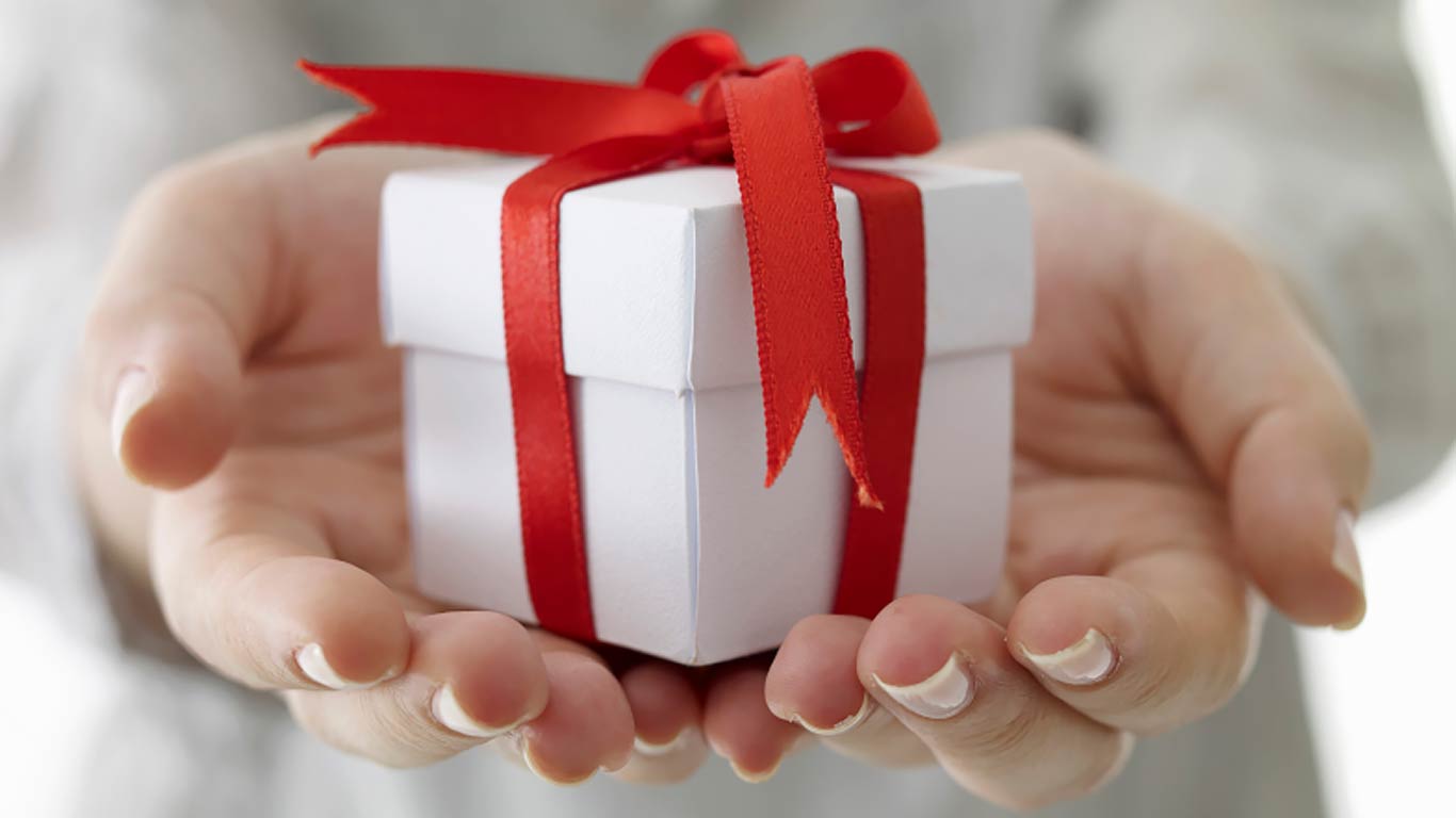 Handing holding a gift box with a red ribbon