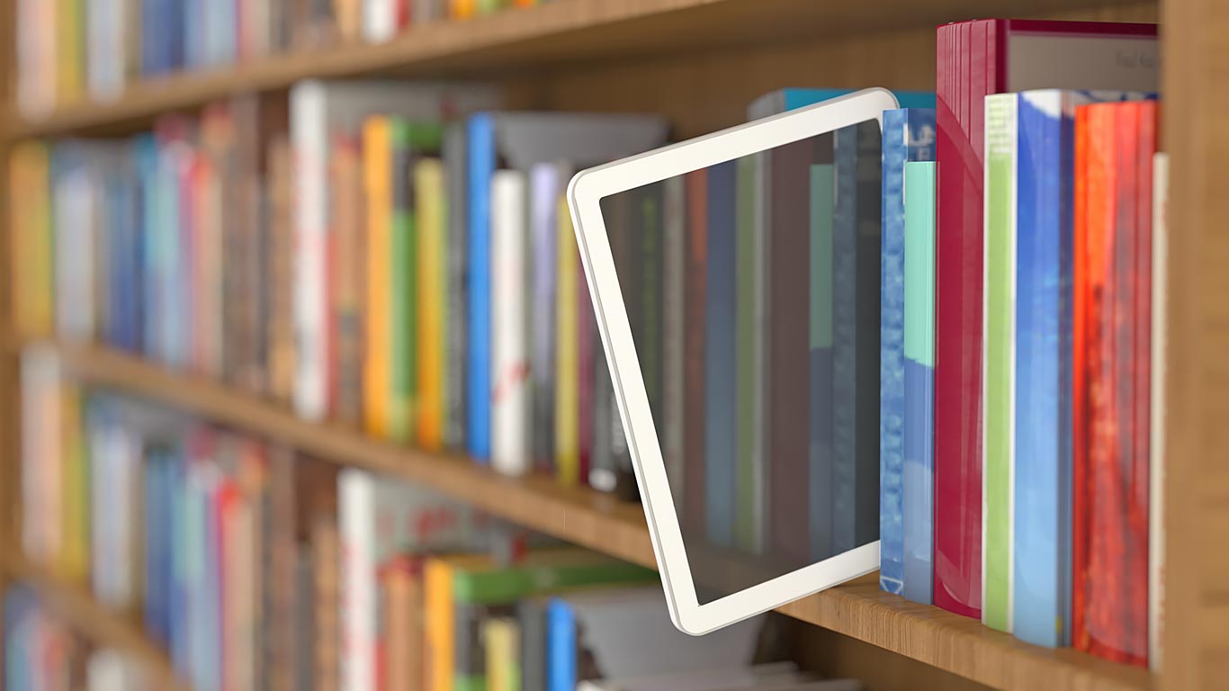 Stack of books and half pulled out tablet - illustrating a digital library
