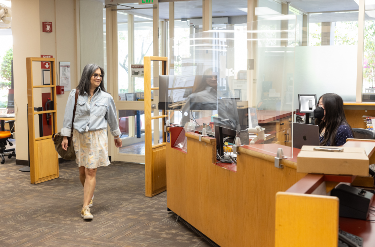 Person walking into Lane Library and being greeted by library staff at information desk